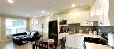 Un appartement moderne comprenant un coin repas, une cuisine et un salon.
