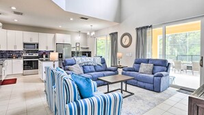 A modern living room with a sofa set, a dining area, and a kitchen. - Private Pool! Game room! Minutes to Disney! Themed rooms! (Kissimmee)