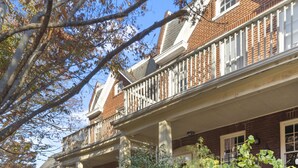 A two-story brick house with a front porch, a small garden, and a sidewalk. - Walk Central. Museum district. Scott's Addition. 2BR - King and full bed.  (Richmond)