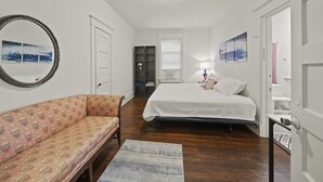 A bedroom with a bed, a sofa, a mirror, and a dresser. - Walk Central. Museum district. Scott's Addition. 2BR - King and full bed.  (Richmond)
