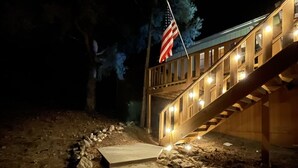 Vista nocturna de una escalera de madera que conduce a un edificio con una bandera estadounidense.