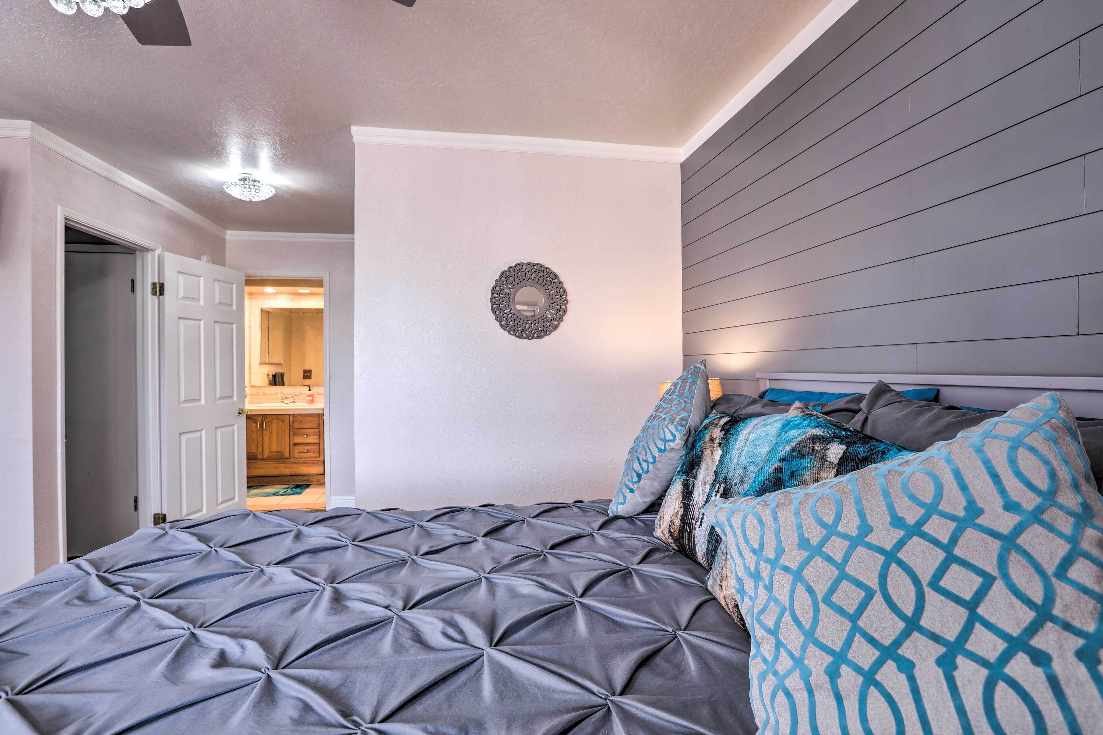 A bedroom with a tufted bed, a circular wall decoration, and a wooden headboard.