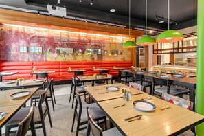 Een restaurantinterieur met zitjes, tafels en een bar.