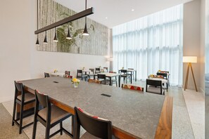 A modern conference room with a long table, multiple chairs, and a decorative wall panel. - Canopy by Hilton New Orleans Downtown (New Orleans)