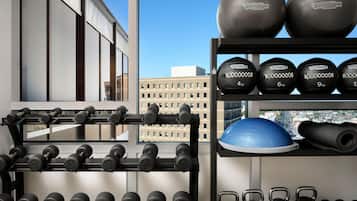 A gym with various weights and exercise equipment, including dumbbells, kettlebells, and medicine balls.