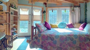 Un dormitorio acogedor con una cama grande, paredes de madera y una ventana con vistas.