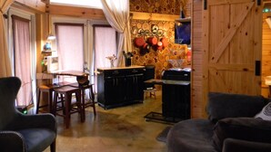 Interior acogedor de una cabaña con comedor, cocina y un gran puerta de madera.