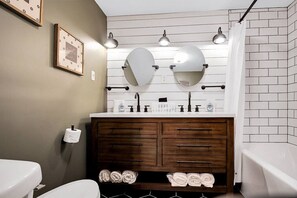 A bathroom with two sinks, a vanity with a mirror, and a shower curtain. - ☆Stunning Derby Home☆ 5 KING BEDS, HOT TUB,FIREPIT (Jeffersonville)