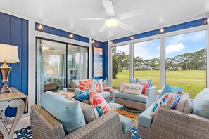 A spacious room with a ceiling fan, large windows, and a view of the outdoors. - "Hidden Gem" - Golf Cart Fun with 5-Star Hosts! (Miramar Beach)