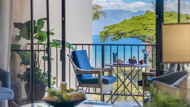 A balcony with a view of a tropical landscape, including a body of water and mountains. - Make Amazing Maui Memories at 1BD AC - Kaanapali Shores 418 (Lahaina)