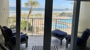 Un balcon avec vue sur la plage, la piscine et l’océan.