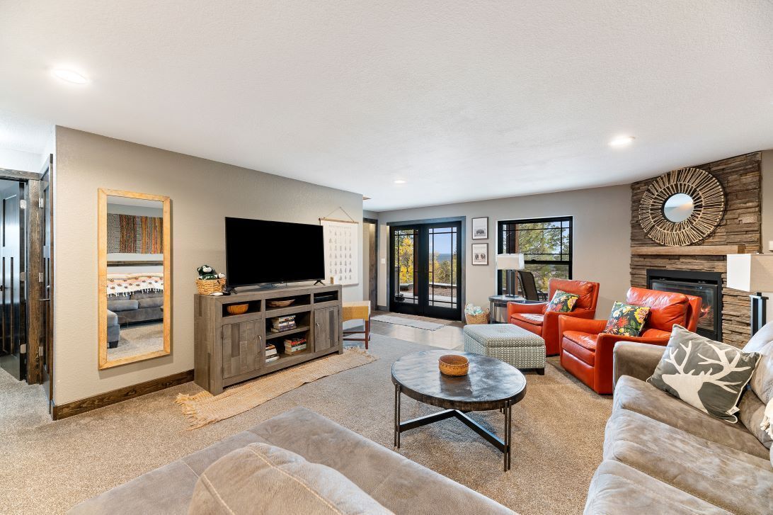 A modern living room with a flat-screen TV, a fireplace, and comfortable seating.