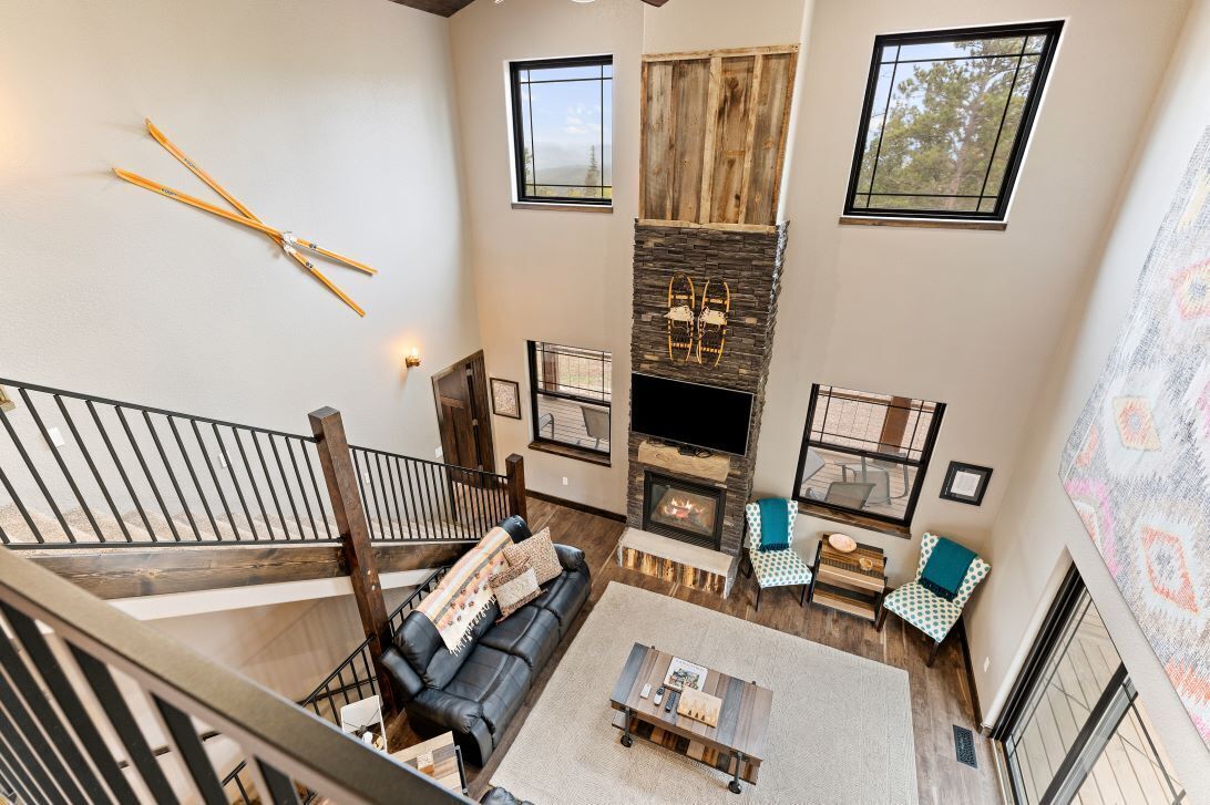 A spacious living area with a fireplace, a black leather sofa, and a wooden coffee table.