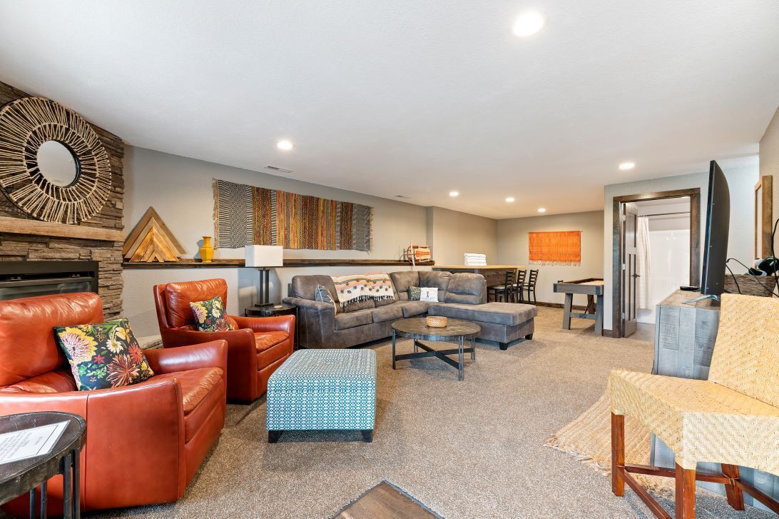 A spacious living room with leather sofas, a coffee table, and a fireplace.