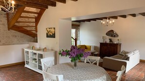 A cozy living room with a round table, a sofa, a cabinet, and a staircase. - Holiday Home in Chilleurs near Château (Chilleurs-aux-Bois)