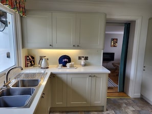 Enjoy cooking in this well-lit kitchen with a two-basin sink and storage.