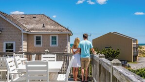 A couple standing on a wooden deck overlooking a beach. - Modern Beachhouse, Pool, 73 Steps to Beach, Deck Fully Loaded, Arcade (Nags Head)