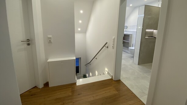 A modern interior with a wooden staircase leading to a bathroom. - Relax in the luxury vacation home Geest & Moor 1 (Großheide)