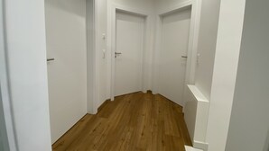 A narrow hallway with white doors and wooden flooring. - Relax in the luxury vacation home Geest & Moor 1 (Großheide)