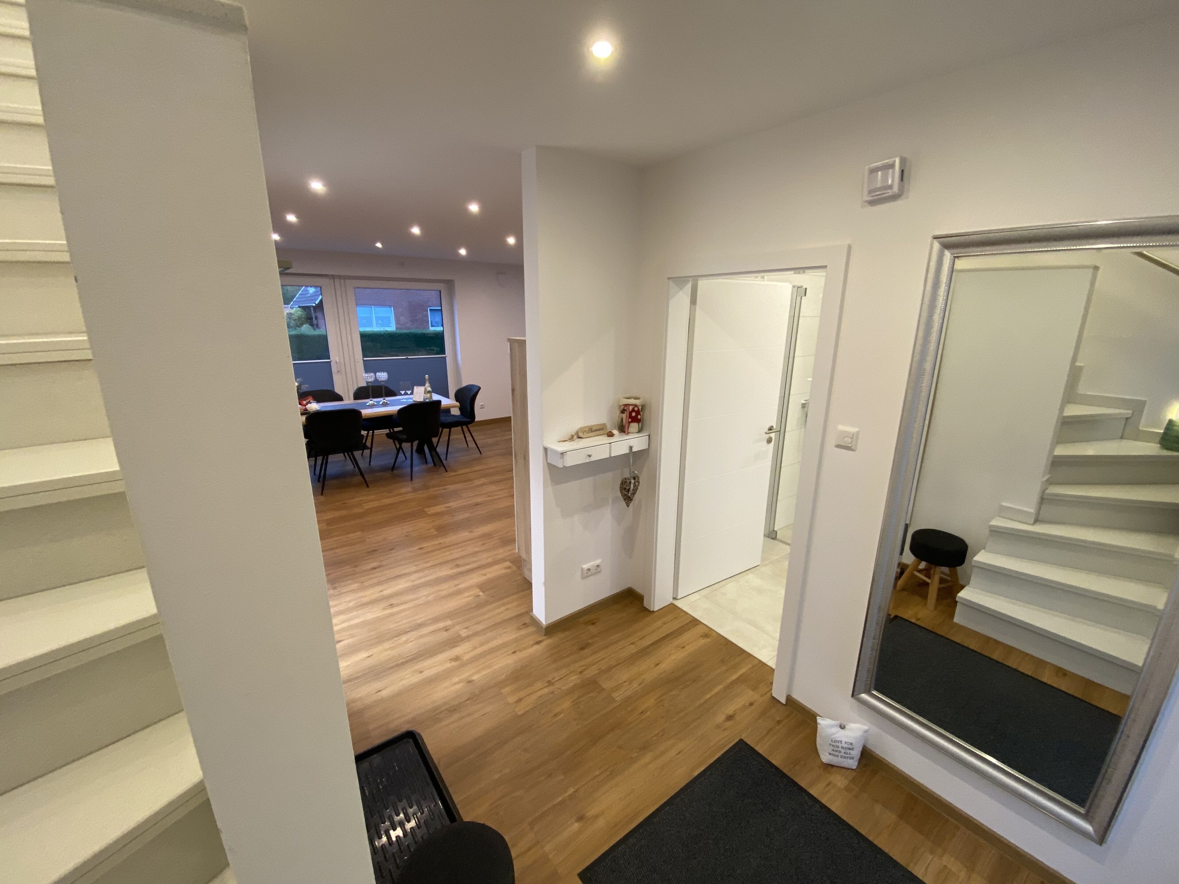 Un intérieur moderne comprenant un coin repas, un escalier et une vue sur l’extérieur.