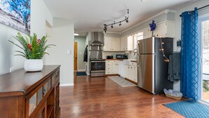 A modern kitchen with white cabinets, stainless steel appliances, and a blue curtain. - Mountain Getaway w/ Hottub, Views, Gamesroom, Fire Pit (Roxbury)