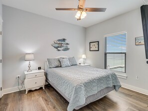Cozy retreat with a large bed, bedside tables, and a ceiling fan.