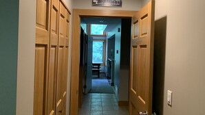 En hall med trädörrar, en skylt med texten ”SKIDTIPS HÄR” och en vy in i ett rum med ett fönster.