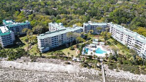 Ein Resort mit mehreren Gebäuden, einem Schwimmbad und umgebender Bepflanzung.