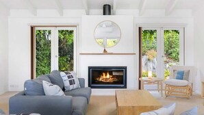 A modern living room with a fireplace, a sofa, a chair, and a coffee table. - Bellarine Lake House Ocean Grove (Ocean Grove)