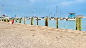 Un port de plaisance où des bateaux sont amarrés le long d’une jetée en béton.