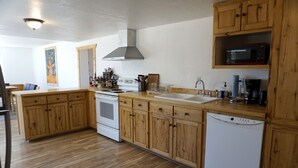Una cocina con armarios de madera, estufa, microondas y lavavajillas.