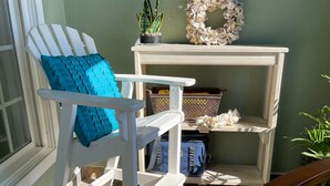 A white Adirondack chair with a blue cushion, a small table with decorative items, and a potted plant. - Perfectly Curated 30A Escape - Steps to Beach & Gulf Place (Santa Rosa Beach)