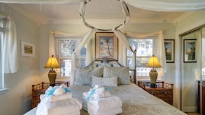 A large bed with a canopy, two bedside lamps, and a view of palm trees through the window. - 30A Beachfront Condo. Steps To The Beach! 3BD,3BA. 25+ Listing (Santa Rosa Beach)