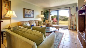A living room with a sofa, armchairs, a coffee table, and a painting on the wall. - 30A Beachfront Condo. Steps To The Beach! 3BD,3BA. 25+ Listing (Santa Rosa Beach)