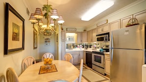 A modern kitchen with a dining area, stainless steel appliances, and a chandelier. - 30A Beachfront Condo. Steps To The Beach! 3BD,3BA. 25+ Listing (Santa Rosa Beach)