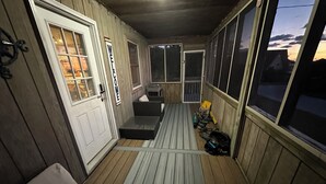 A covered porch with a bench, a welcome sign, and a view of the sunset. - Waterfront, Dog friendly, & private boat ramp (Frisco)