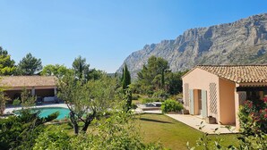 A villa with a swimming pool, a garden, and a view of rocky mountains. - Provençal Villa in the Heart of Sainte-Victoire (Saint-Antonin-sur-Bayon)