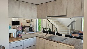 A modern kitchen with granite countertops, wooden cabinets, and a built-in stove. - Provençal Villa in the Heart of Sainte-Victoire (Saint-Antonin-sur-Bayon)
