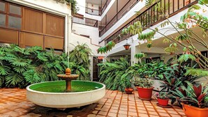 A courtyard with a central fountain, surrounded by potted plants and a tiled floor. - Home2Book Central Studio near Playa del Muelle (Puerto de la Cruz)