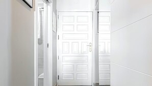 A hallway with a white door, a framed picture on the wall, and a ceiling light. - Home2Book Central Studio near Playa del Muelle (Puerto de la Cruz)