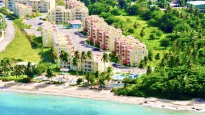 Un complexe hôtelier comprenant plusieurs bâtiments, une plage et une eau d’un bleu cristallin.
