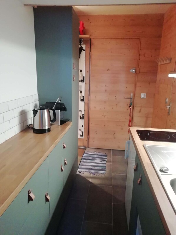 A narrow kitchen with a wooden countertop, a kettle, and a stove. - Les Arcs 1800: Renovated 2-bedroom apartment in the Bellecote residence at the foot of the slopes (Bourg-Saint-Maurice)