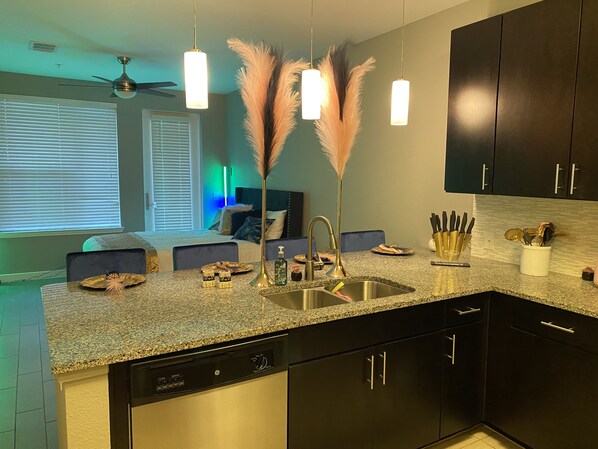 Enjoy cooking in this well-equipped kitchen with a granite countertop, stainless steel sink, and oven.
