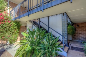 A two-story building with a blue staircase and a brick exterior.