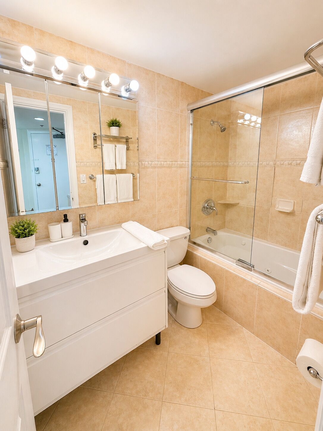 A bathroom with a sink, toilet, bathtub, and a glass shower enclosure.