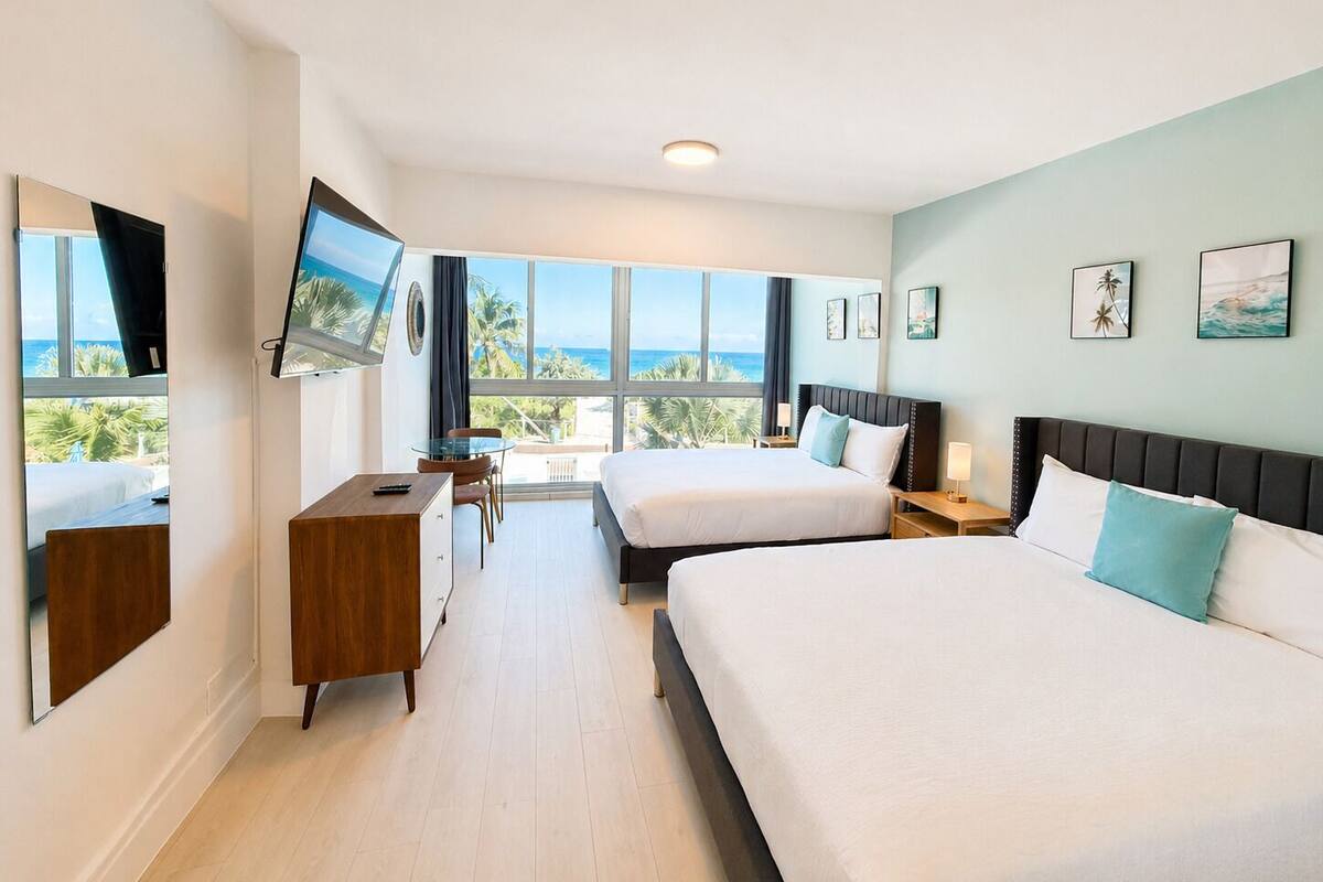 A hotel room with a large bed, a desk, and a TV.