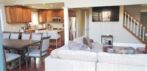 Relax in this open-plan living space with a kitchen, dining area, and comfortable sofa.