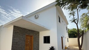 Una casa moderna con fachada de piedra, puerta de madera y camino de entrada de grava.