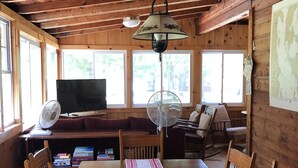 A wooden dining area with a table, chairs, a bench, and a fan. - Spacious Cottage with Lake Access in quiet lakeside community (Georgia)