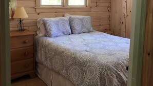 A bedroom with a bed, a nightstand, a lamp, and a ceiling fan. - Spacious Cottage with Lake Access in quiet lakeside community (Georgia)